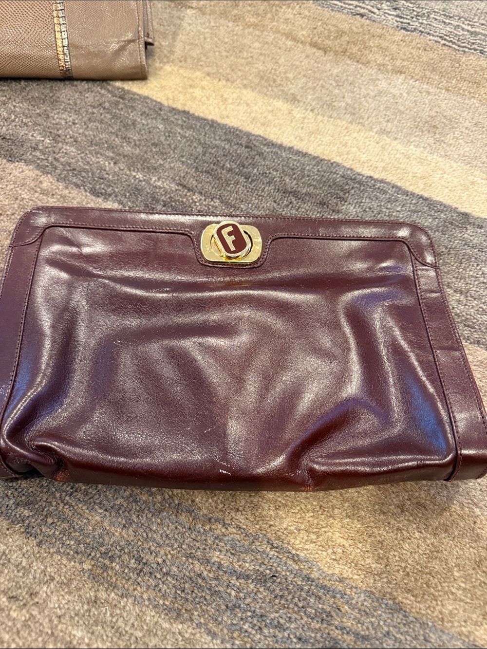 Salvatore Ferragamo Burgundy Leather Clutch with Gold Emblem